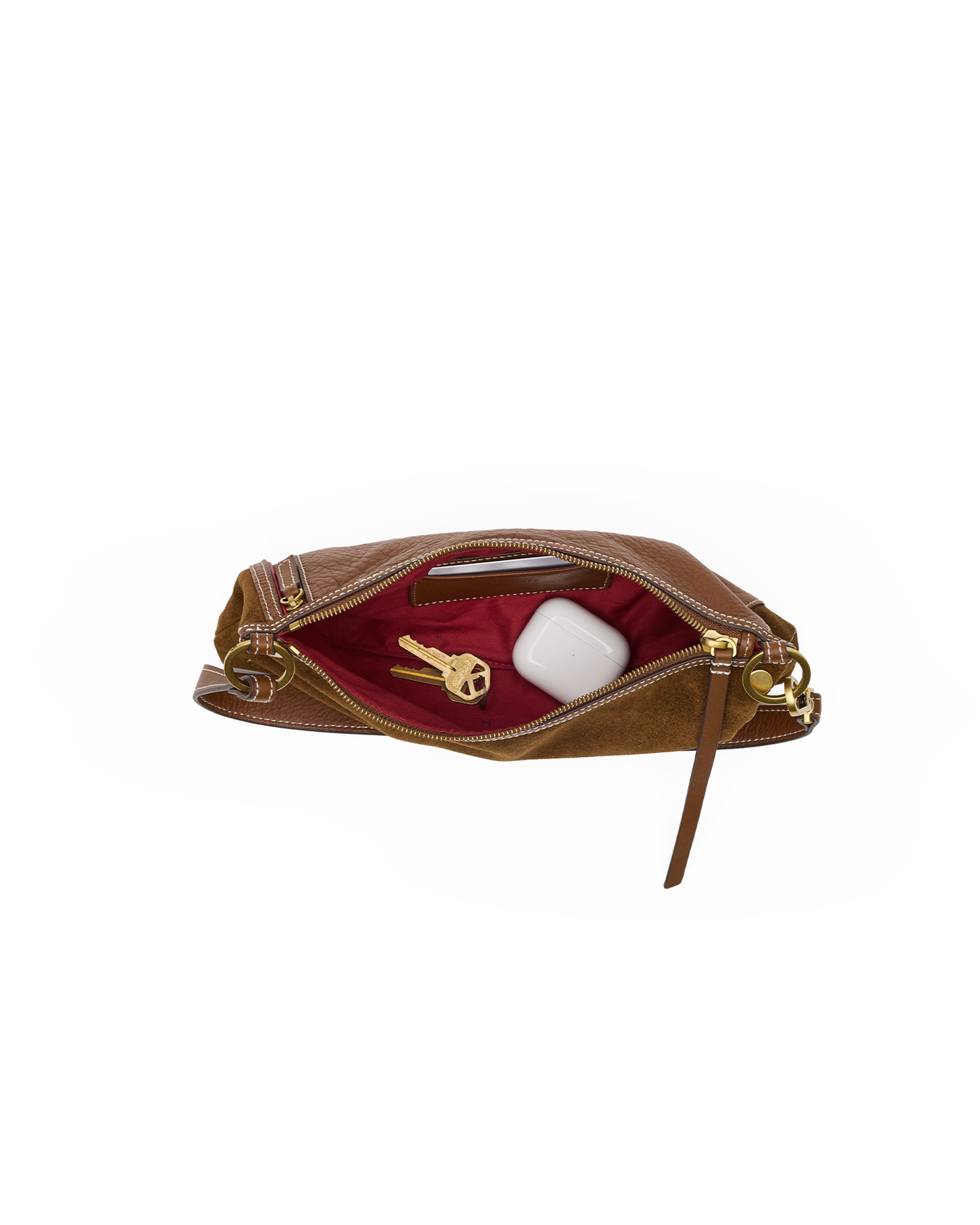 A brown leather clutch bag shown open, revealing a deep burgundy red interior lining with gold-tone hardware. Inside, a gold key and a white rectangular item are visible.