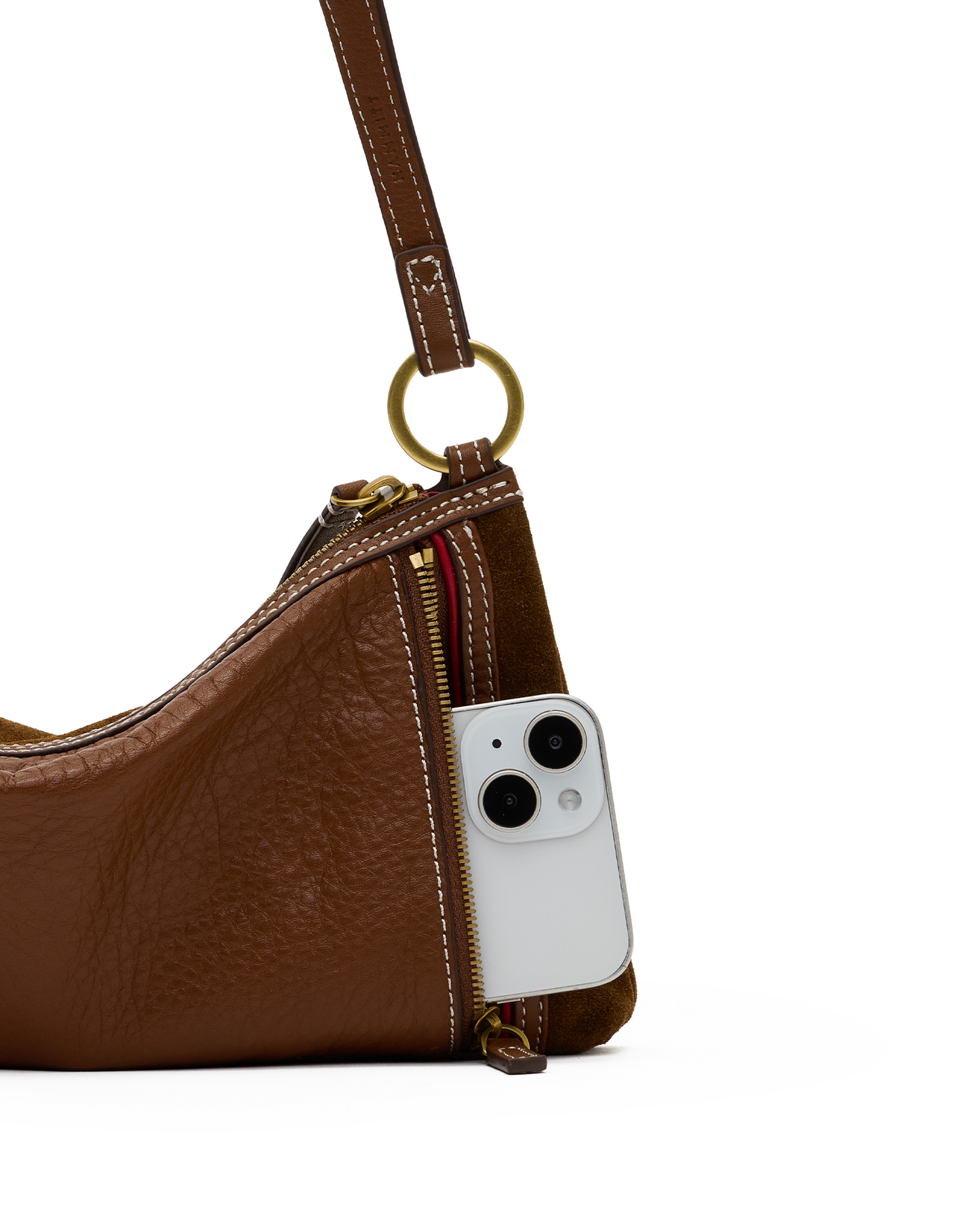 A close-up of a brown textured leather shoulder bag with a gold-tone ring and zipper, shown with a white smartphone inserted into the side zip pocket.