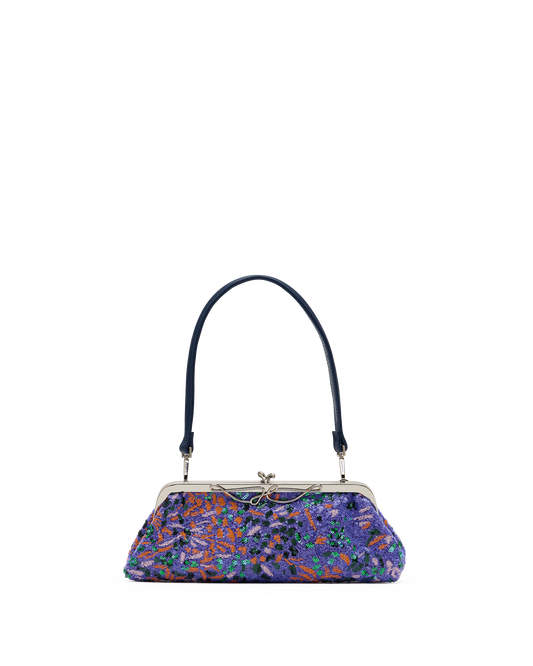 A small handbag with a dark navy blue handle and a colorful floral patterned body in shades of purple, blue, orange, and green, featuring a silver-tone kiss-lock closure.