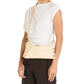 A model wearing a white t-shirt and dark brown pinstriped trousers, carrying a cream-colored shoulder bag with gold hardware and a gold chain strap.