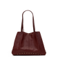 A dark burgundy leather tote bag with double shoulder straps and gold-tone metal studs along the bottom edge, shown against a plain white background.