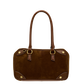 A brown suede and leather handbag with double top handles, gold-tone hardware, and contrast stitching
