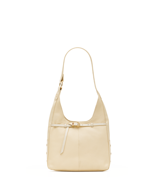 A light beige leather shoulder bag with a single strap and a decorative front strap detail, shown against a plain white background.