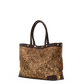 A structured tote bag with a textured, glittery gold and brown body, dark brown leather handles and trim, and gold-tone metal studs, shown against a plain white background.