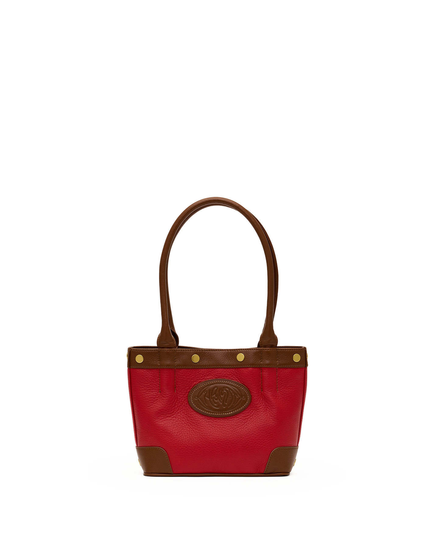 A red leather handbag with brown leather trim, double top handles, and a circular embossed logo patch on the front, set against a plain white background.