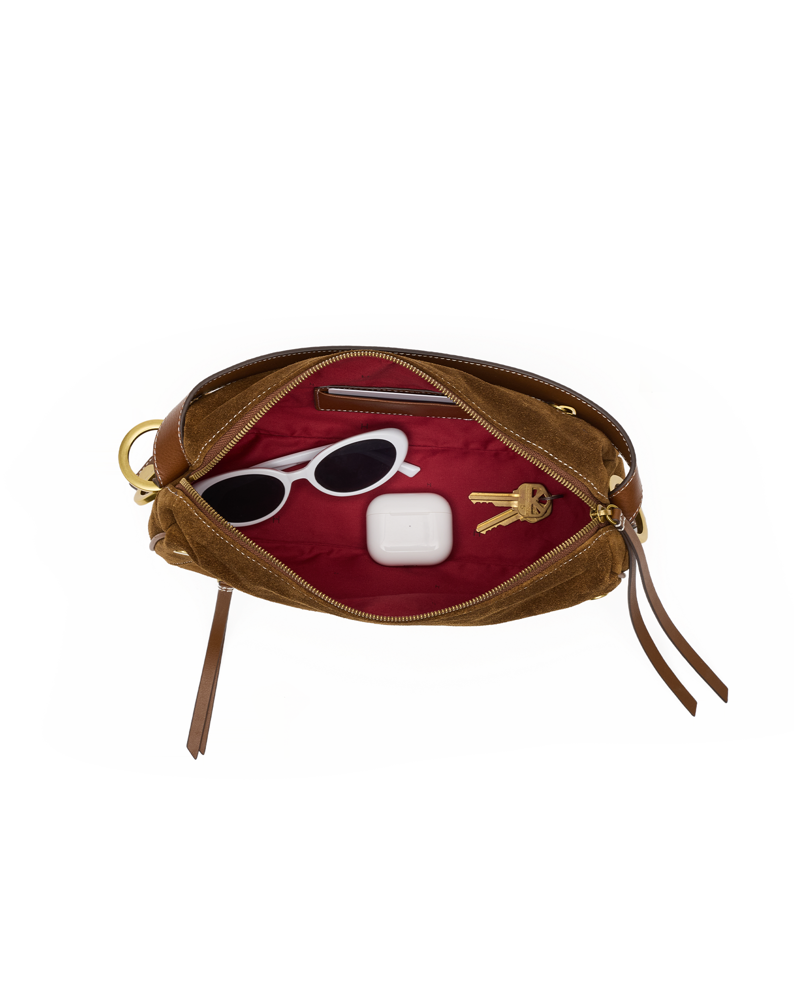An open brown leather pouch with a deep red velvet interior, shown against a plain white background. Inside, a pair of white sunglasses and a white rectangular item are arranged.