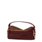 A burgundy leather shoulder bag with gold-tone hardware, featuring a top handle, a zippered front pocket, and a signature interlocking O-ring detail on the side, shown against a plain white background.
