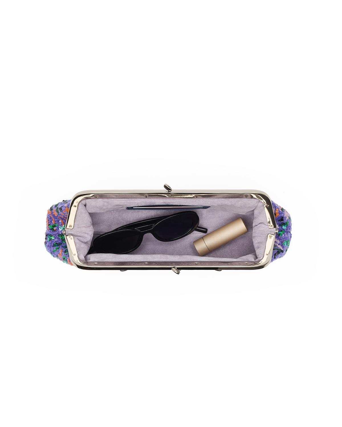 An open rectangular clutch or cosmetic bag with a colorful floral patterned exterior, a silver-tone metal frame, and a light lavender interior. Inside, black sunglasses and a beige cylindrical cosmetic item are placed on a plain white background.