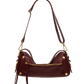 A dark burgundy leather shoulder bag with gold-tone hardware, featuring a curved silhouette, a front zip pocket, and a long shoulder strap, shown against a plain white background.