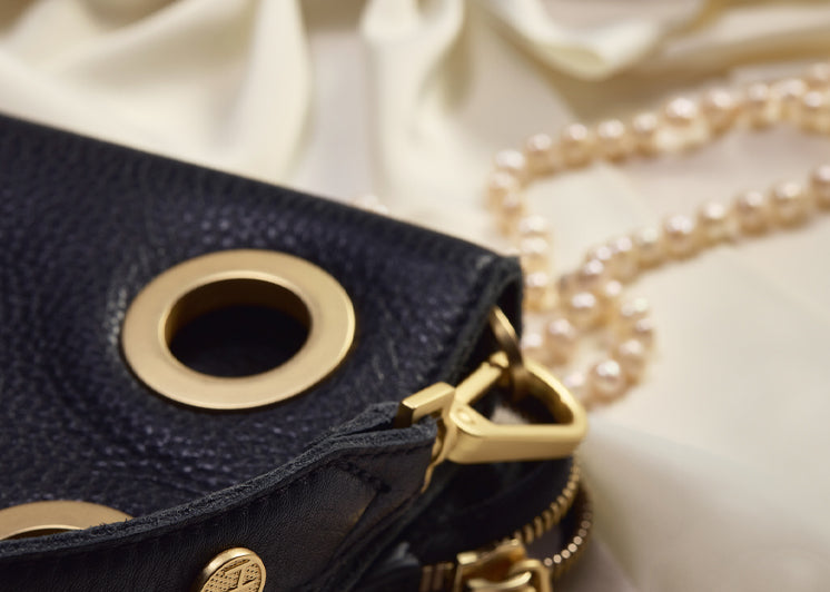 Image of the corner of Montana clutch sml in black brushed gold on white fabric and pearls 