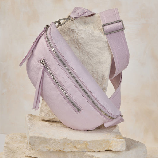Charles med in pastel lilac sitting atop white stone tiles. 
